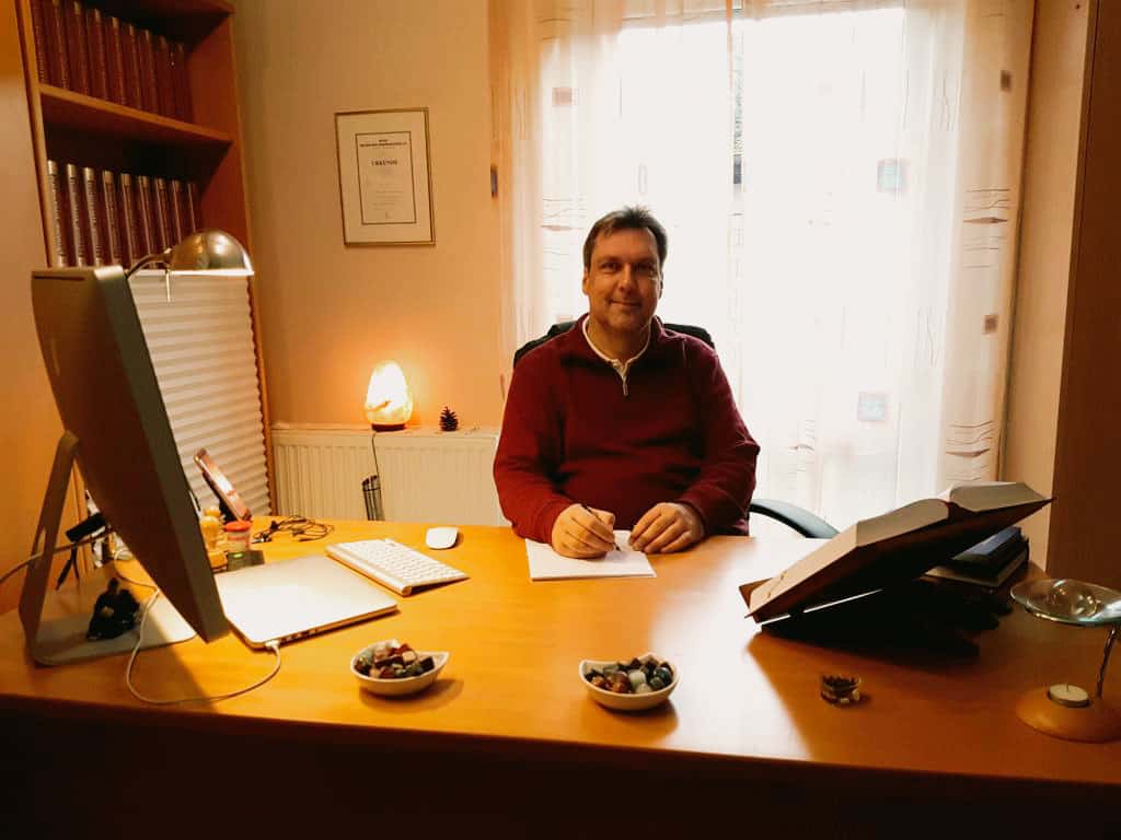 Detlef Rathmer an seinem Schreibtisch in der Praxis